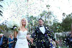 a newly married couple walking through confetti