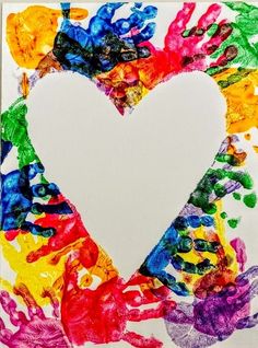 a heart made out of colorful handprints on a piece of paper with paint splattered all over it