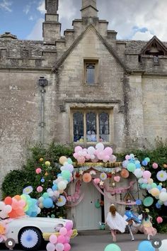 a car parked in front of a building with balloons