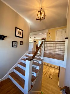 there is a light that is on above the stairs in this house with wood flooring