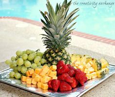 a plate full of fruit next to a swimming pool