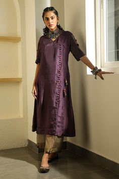 Dark purple overlap tunic with asymmetric placket button opening, handmade potli buttons from scrap fabric and tassel side tie-up.
Component: 1
Embroidered
Neckline: V Neck
Sleeve Length: Half
Fabric: Silk
Color: Purple
Side tie-up
Panelled sleeves
Overlap tunic
Note: Pant worn by the model is not for sale - Aza Fashions Silk Kurti Designs, Tunics Online, Silk Kurti, Potli Bag, Kurti Embroidery Design, Kurti Collection, Scrap Fabric, Embroidered Neckline, Kurta With Pants