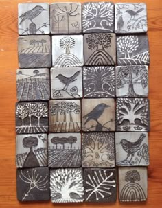 a wooden table topped with lots of different types of ceramic tiles on top of each other