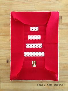 an open red box with white polka dots on the side and ribbon at the bottom