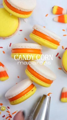 candy corn macaroons with orange and white frosting on them are being cut in half