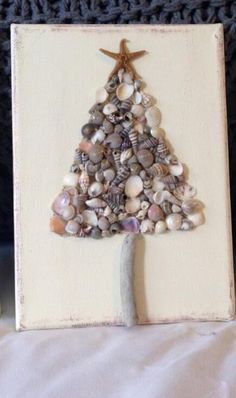 a christmas tree made out of seashells is displayed on a white board with a starfish