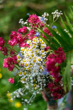 a bouquet of wildflowers and other flowers in a vase on a table outside