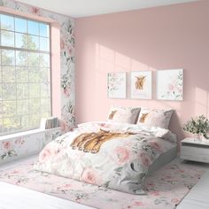 a bedroom with pink walls and floral bedspread on the bed, along with two framed pictures