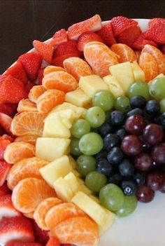 a cake with fruit arranged in the shape of a rainbow