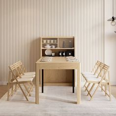 a wooden table with four chairs in front of it and a shelf on the wall