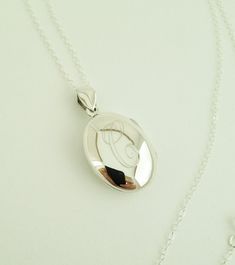 "This sterling silver locket necklace makes a beautiful present for any mother, grandmother, friend or loved one.. I will engrave an Initial onto the small oval locket which holds two photos. Pendants and necklace are sterling silver. Hangs from a long 30\" sterling silver chain. Locket- sterling silver Necklace- 30\" long, sterling silver How to Order: 1. Place item or items in cart. (If purchasing more than one item the shipping will automatically be combined. For 5 or more items, contact me f Cheap Nickel-free Locket Necklace For Keepsake, Luxury Engraved Sterling Silver Locket Necklace, Elegant Initials Locket Necklace For Anniversary, Elegant Anniversary Locket Necklace With Initials, Classic Locket Necklace With Engraving For Keepsake, Classic Personalized Pendant Locket Necklace, Elegant Medallion Locket Necklace With Initials, Sterling Silver Oval Locket Necklace Gift, Sterling Silver Oval Pendant Jewelry For Personalized Gift