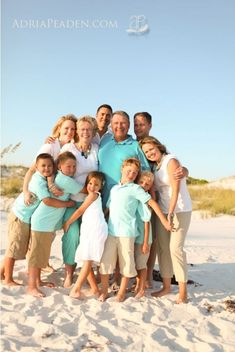 a family poses for a photo on the beach in front of sand dunes at sunset