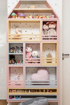 a pink doll house with lots of toys in it