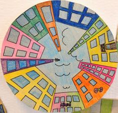 a drawing on a paper plate with colored pencils in the shape of a city