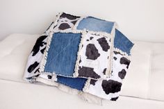 two pillows made out of old jeans are sitting on top of each other in the shape of cows