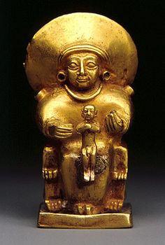 an ancient gold figurine sitting on top of a table