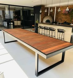 a table with four chairs in front of an open kitchen and dining area behind it