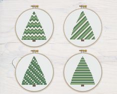 four cross stitch christmas trees in green and white