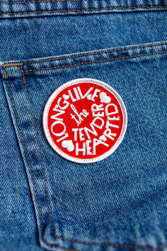 a red and white sticker on the back of a pair of blue jean pants