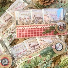 some christmas cards are laying on top of each other and surrounded by pine cone cones