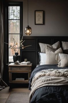 a bedroom with black walls and white bedding is pictured in this image, there are two lamps hanging above the bed