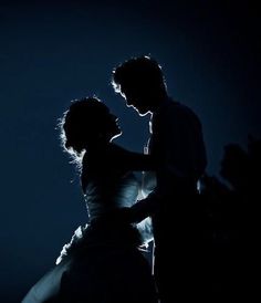 a man and woman dancing in the dark