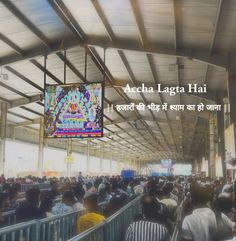 a large group of people in a building with a sign that says accha lagta hai