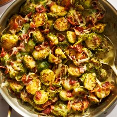 a pan filled with brussel sprouts covered in cheese and sauces