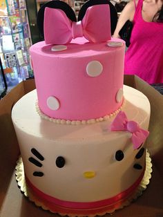 a hello kitty cake with pink and white frosting is on display in a store