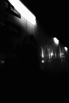 black and white photograph of people walking in the dark