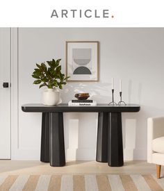 a table with two vases on it in front of a white wall and chair