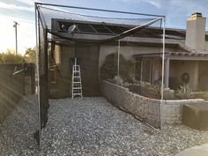 a house with a large screen in front of it and a ladder up to the roof