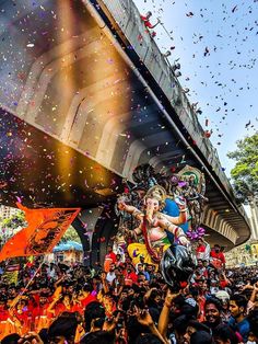 a large group of people standing around and watching a woman on a float in the air