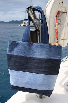 a blue and white striped tote bag sitting on top of a boat in the ocean