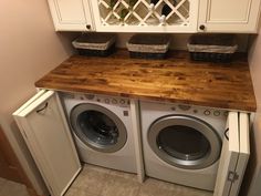 a washer and dryer sitting next to each other in a room with white cabinets