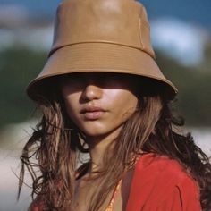 a woman wearing a tan hat with long hair