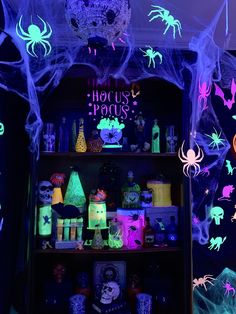 a shelf with halloween decorations on it in front of a purple wall and black background