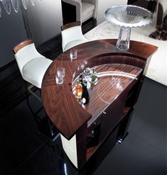 a wooden table with two white chairs and a wine glass on the top, in front of a mirror