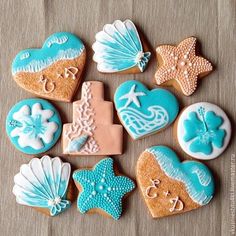 decorated cookies arranged in the shape of hearts, seashells and starfish on a table