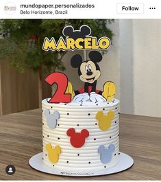 a mickey mouse birthday cake with the number two on it's top and name in spanish