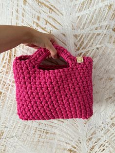 This adorable pink crochet mini handbag is perfect for the modern and trendy woman in your life. This small bag is not only fashionable but also functional, making it the ideal accessory for any outfit. It would make a lovely Christmas gift for her, adding a touch of charm to her wardrobe. Handcrafted with care, this purse is a unique and stylish addition to any collection. The bag is made of cotton cord having OEKOTEX Standard 100 Certificate. The small handbag is available in many colors.  In Pink Crochet Purse, Trendy Handheld Crochet Bag For Gift, Trendy Handheld Crochet Bag As Gift, Pink Hand Knitted Bags For Gifts, Hand Knitted Pink Bags For Gifts, Trendy Pink Crochet Bags, Handmade Pink Crochet Shoulder Bag, Pink Hand Knitted Bags For Daily Use, Casual Handmade Pink Crochet Bag