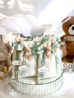 two teddy bears sitting next to each other on a glass table with white and green ribbons