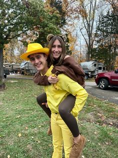 two people dressed in costumes are posing for a photo outside on the grass with their arms around each other