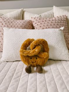 a stuffed animal sitting on top of a bed next to pillows