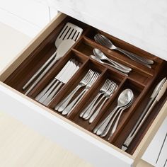 an open drawer with silverware in it