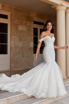 a woman in a wedding dress standing on some steps