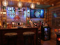 a bar with three stools and darts on the wall