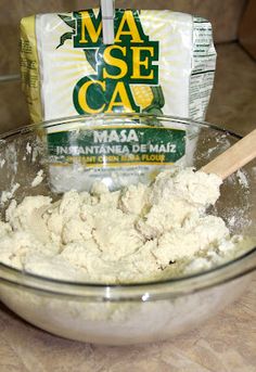 a bowl filled with white flour next to a bag of mase caa on top of a counter