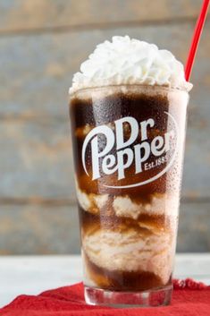 a drink with whipped cream and dr pepper on top