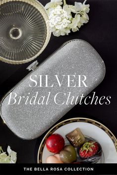 silver bridal clutches on a plate with strawberries and flowers in the background